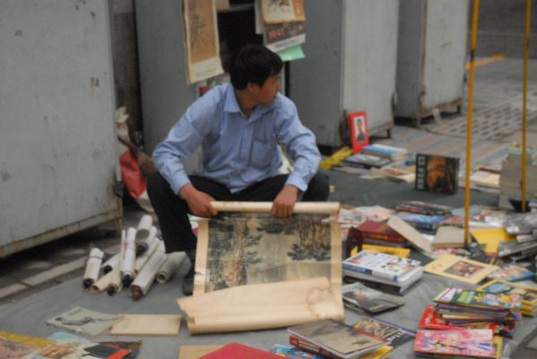 Торговец литографиями на улочке букинистов. Снято в Пекине в 2010 году